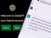 A picture of the ChatGPT login page on a computer screen and, in front of it, the chatbot itself on a phone screen. The picture illustrates a story about publisher and industry responses to the UK government's proposal to create an opt-out copyright regime in relation to AI data mining.